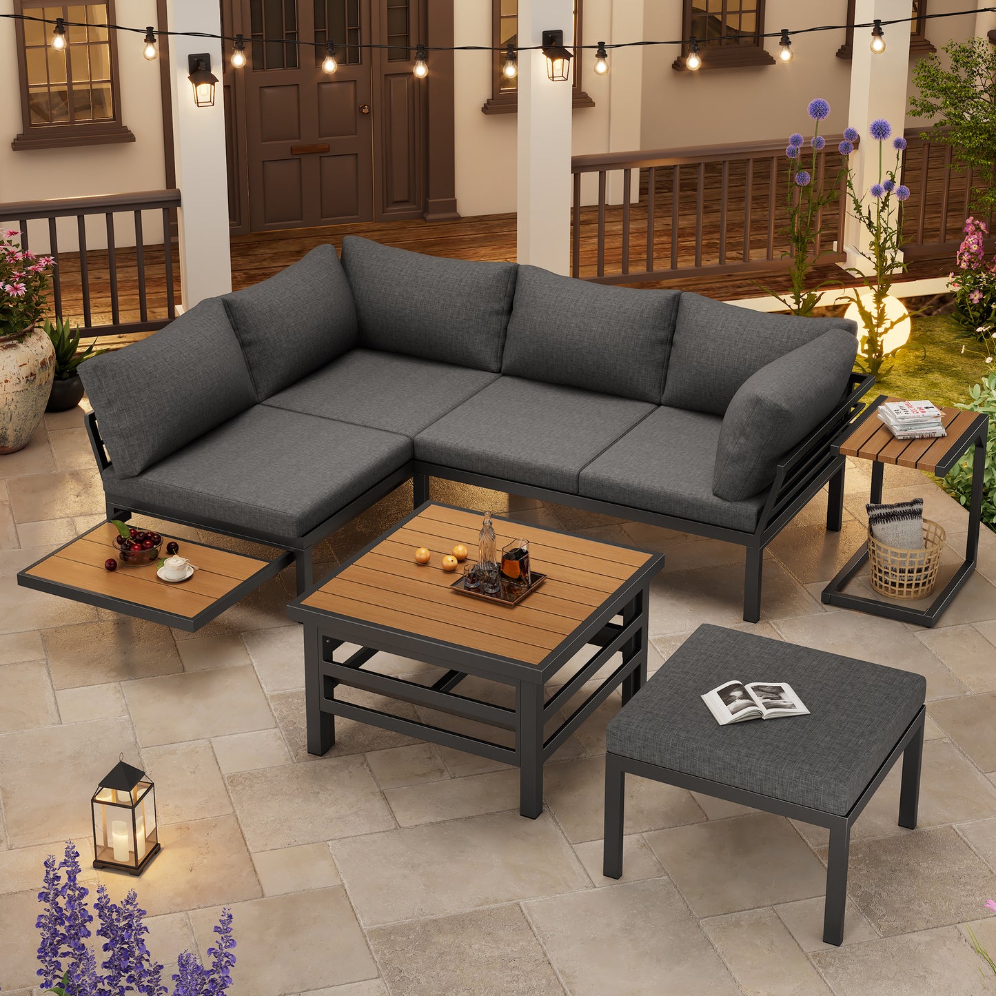 Outdoor patio furniture set with gray cushions and wooden coffee table on a stone patio.