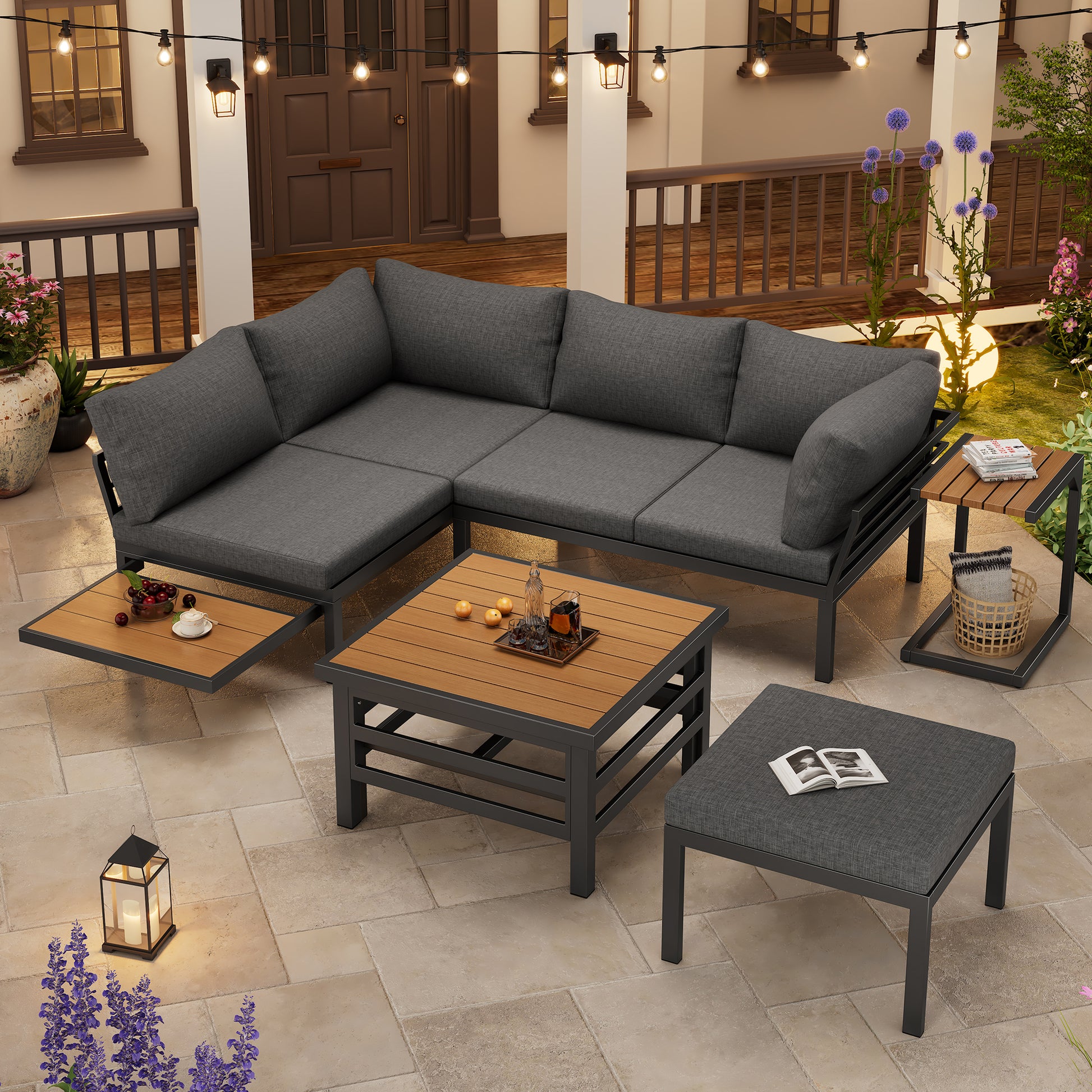 Outdoor patio furniture set with gray cushions and wooden coffee table on a stone patio.